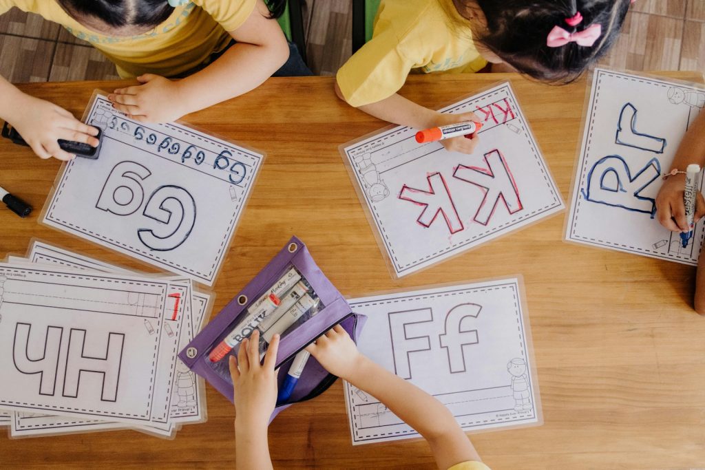 A group of children sitting at a table with paper cut outs