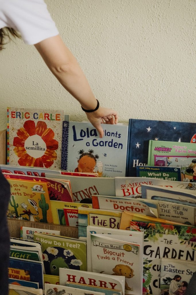 A person reaching for a book on a shelf